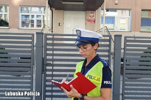 policjantka sprawdza oznakowanie na drodze