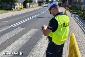 policjant sprawdza oznakowanie na drodze