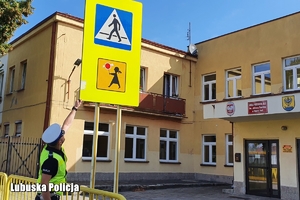 policjantka sprawdza oznakowanie na drodze