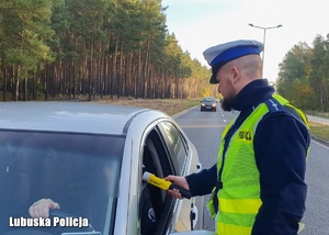 Policjant sprawdza stan trzeźwości kierowcy.