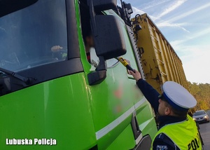 Policjant sprawdza stan trzeźwości kierowcy.