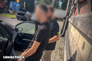 policjant prowadzi zatrzymanego mężczyznę