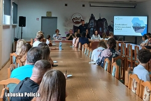 policjant rozmawia z ludźmi w klasie