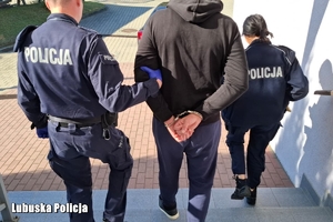 policjanci prowadzą zatrzymanego mężczyznę