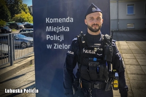 policjant stoi przy banerze