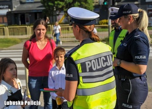 Policjantki rozmawiają z dziećmi i rodzicami podczas akcji profilaktycznej.