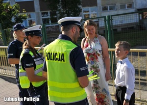 Policjanci rozmawiają z chłopce i jego mamą podczas akcji profilaktycznej.