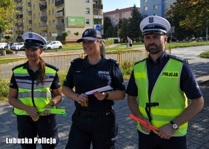 Policjanci stojący przed szkołą podczas akcji profilaktycznej.