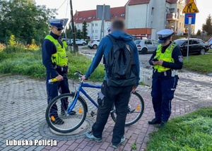 Policjanci rozmawiają z rowerzystą.