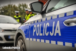radiowóz i policjanci w tle