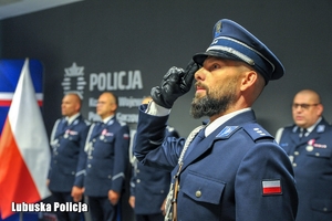 Policjant oddaje honory.