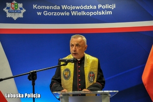 Kapelan policyjny przemawia do zgromadzonych osób.