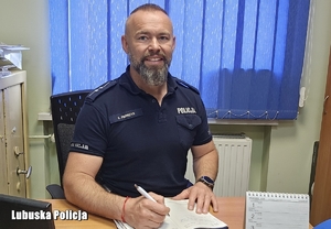 policjant siedzi  przy biurku