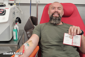 mężczyzna trzyma legitymację i odznakę