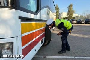 policjant kontroluje stan autokaru