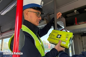 policjant kontroluje wyposażenie autokaru