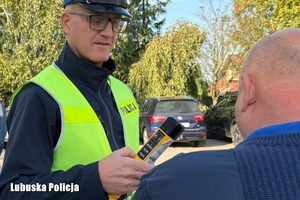policjant kontroluje stan trzeźwości kierowcy autokaru
