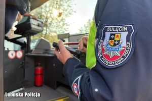 policjant kontroluje stan autokaru