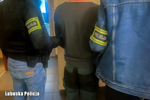 policjanci prowadzą zatrzymanego mężczyznę