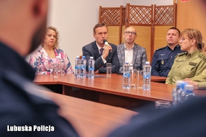 osoby siedzą na sali konferencyjnej