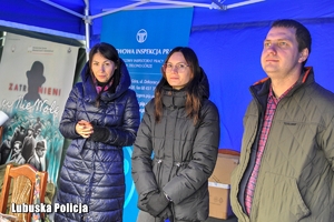 osoby stoją pod namiotem