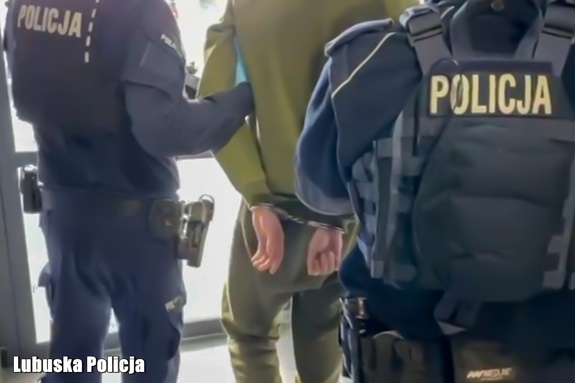 policjanci prowadzą zatrzymanego mężczyznę