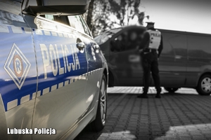 radiowóz i policjant w tle