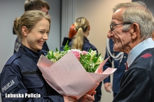 Mężczyzna wręcza kwiaty policjantce