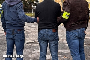 policjanci prowadzą zatrzymanego mężczyznę