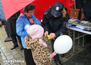 Policjantka przyczepia odblask dziecku