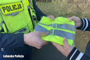 policjant przekazuje kamizelkę