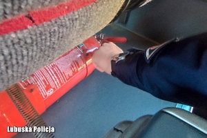 policjant sprawdza gaśnicę