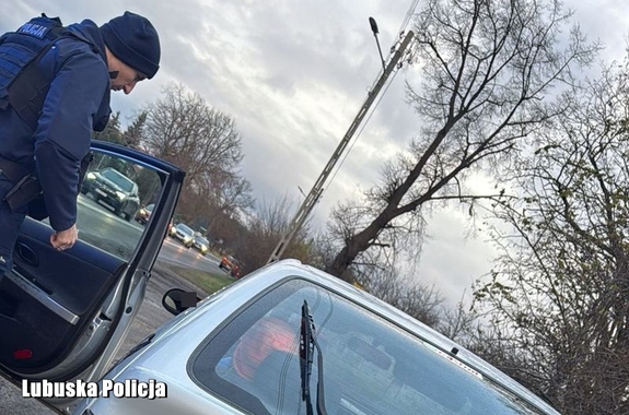 policjant stoi przy samochodzie