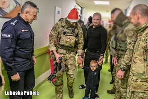 policjanci prowadzą dziecko przez korytarz