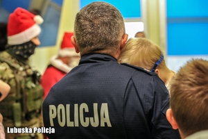 Policjant z dzieckiem na rękach.