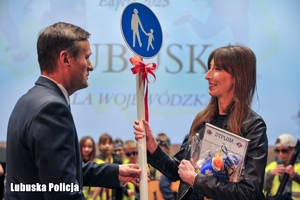 mężczyzna wręcza nagrody kobiecie