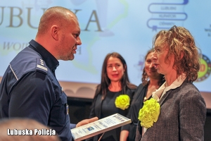policjant wręcza nagrodę kobiecie