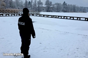 policjantka spogląda na zamarznięty akwen