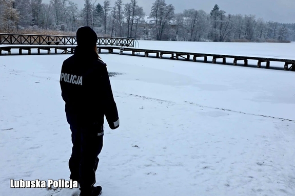 policjantka spogląda na zamarznięty akwen