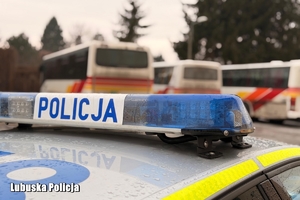 radiowóz obok autokarów