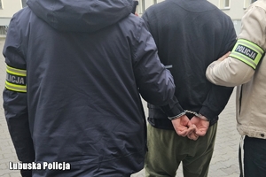 policjanci prowadzą zatrzymanego mężczyznę