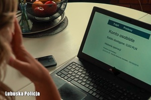 osoba siedzi przed laptopem