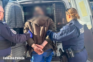 policjanci prowadzą mężczyznę do radiowozu