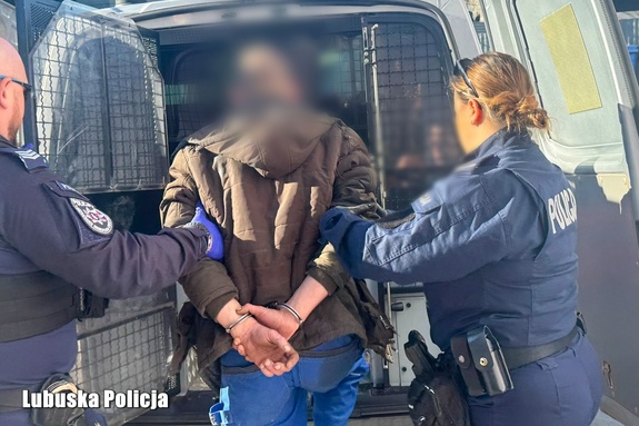 policjanci prowadzą mężczyznę do radiowozu