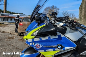policyjny motocykl i policjant w tle