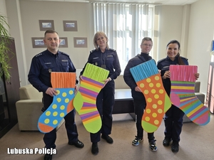 policjanci i chłopiec trzymają kolorowe skarpetki
