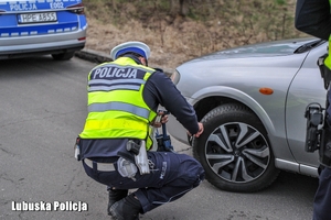 policjant kontroluje stan ogumienia