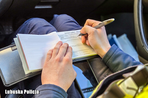 Policjant wypisuje mandat