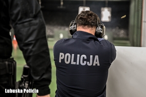 Policjant strzela na strzelnicy.