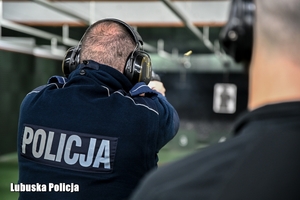 Policjant strzela na strzelnicy.